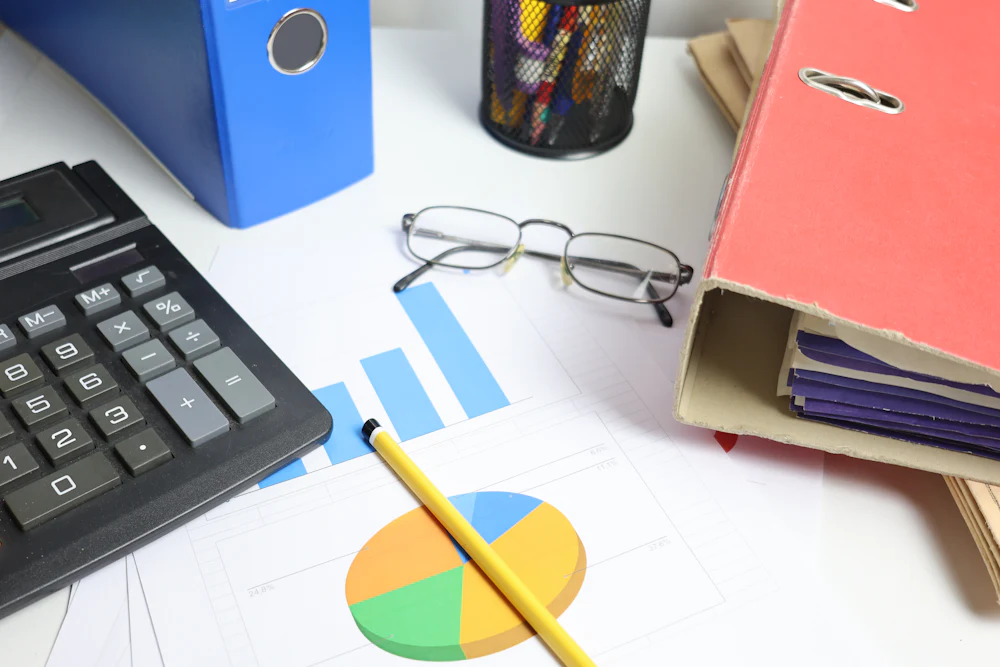 Mesa de trabalho com calculadora, pastas e relatórios